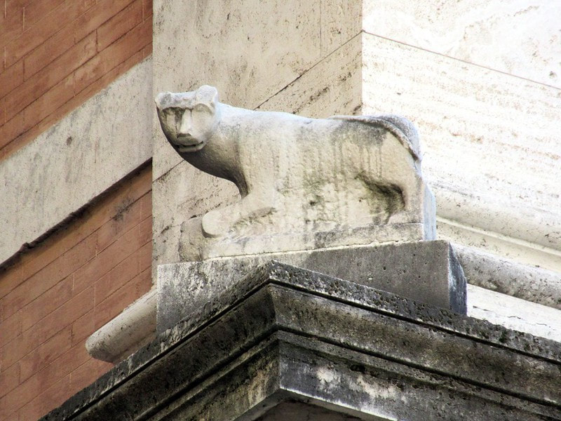 A stone cat from temple of Isis sits on a cornice of the Palazzo Grazioli, Rome
